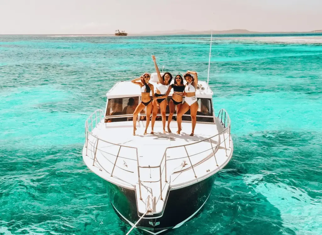 Group partying on a boat in Miami with music, drinks, and skyline views during a boat party