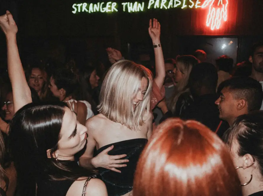 Crowd dancing inside a Miami nightclub with DJs, lights, and VIP atmosphere