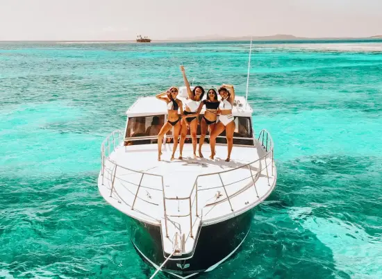 Group partying on a boat in Miami with music, drinks, and skyline views during a boat party